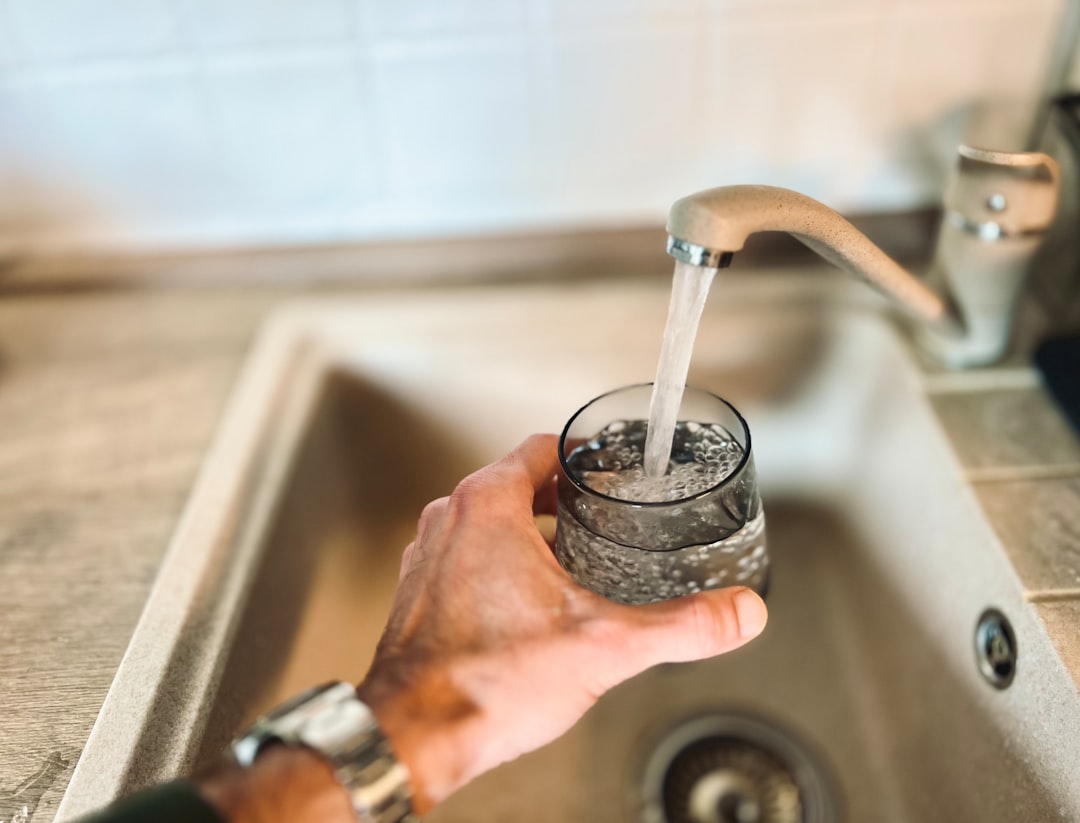 a-hand-holding-a-glass-of-water-muohsyeqbho